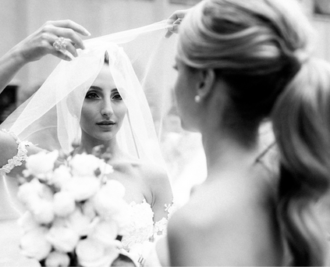 Wedding bride adjusts her veil while checking her makeup in the mirror 10 SECRETS TO WEDDING DAY MAKEUP BEAUTY