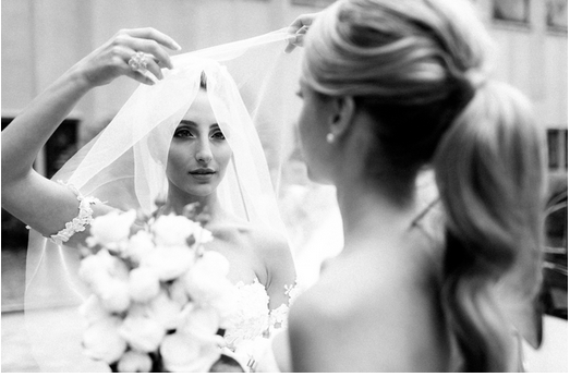 Wedding bride adjusts her veil while checking her makeup in the mirror 10 SECRETS TO WEDDING DAY MAKEUP BEAUTY
